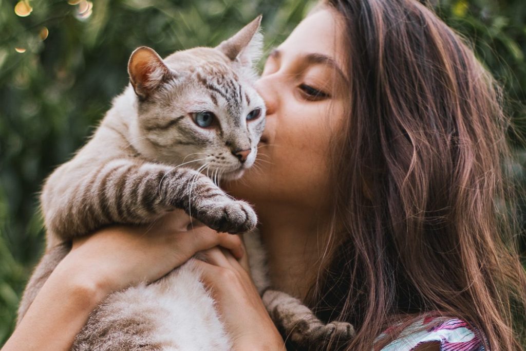 girl kissing her cat